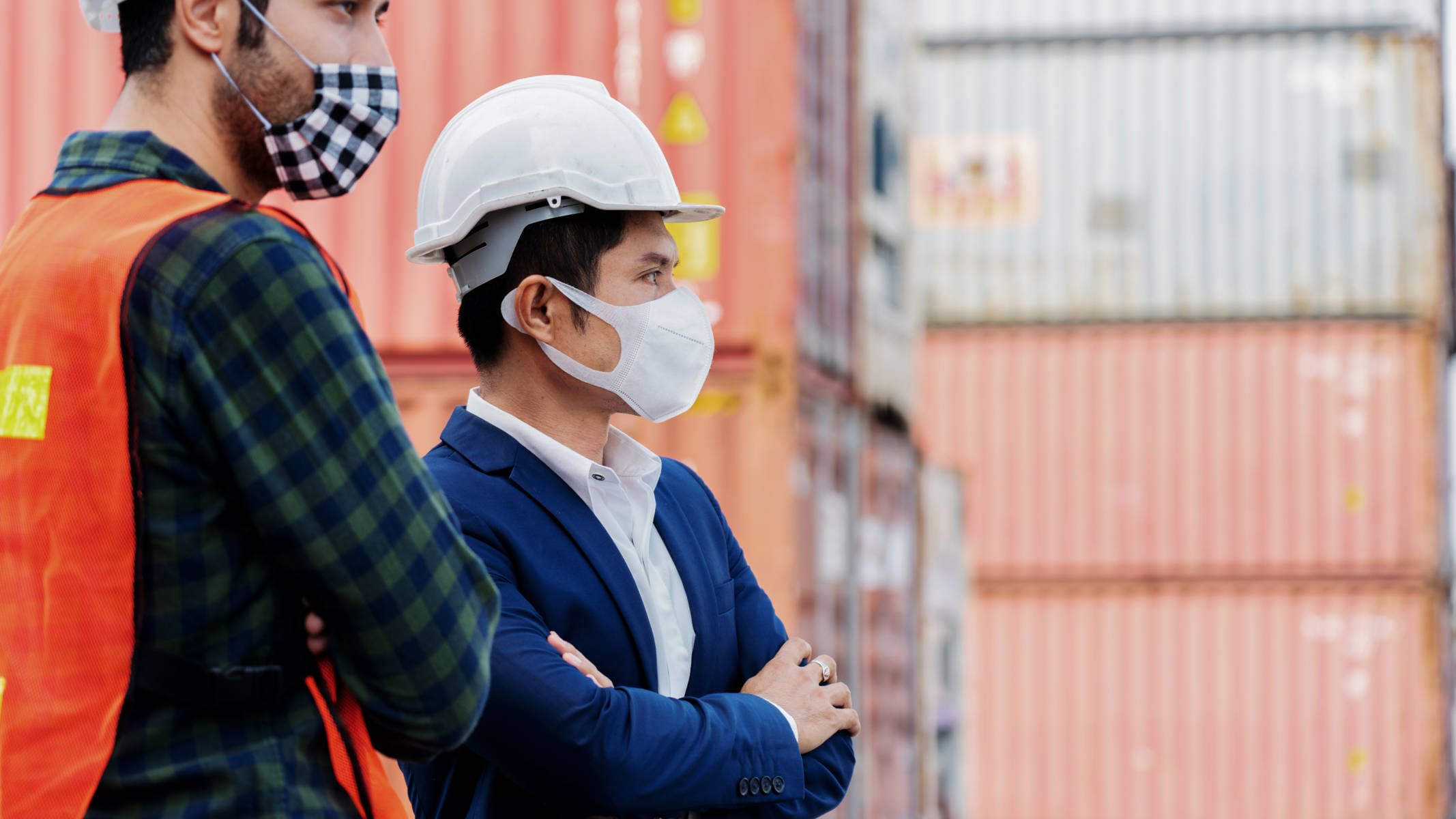 Construction workers or engineer wear safety helmet And the mask in the factory Or container. Prevent accidents at work or dust, secretion spread Coronavirus. Social distancing. Concept New Normal