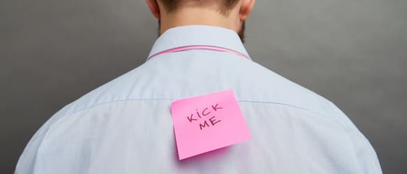 a man with a kick me post-it on his back