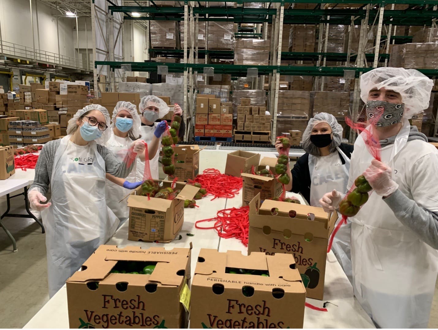 Addison Group employees volunteering in a factory packing boxes