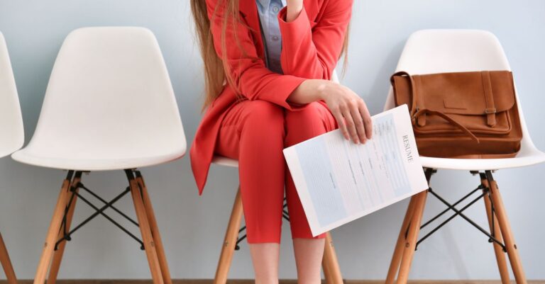 Addison Group's blog about red flags during the job search. Featuring a woman in a suit with a resume in hand.