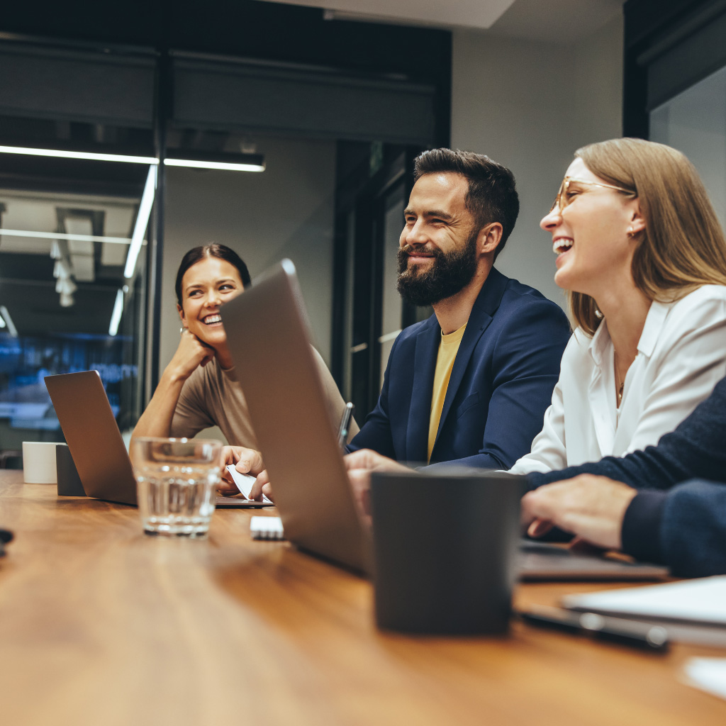 Addison Group's internal recruiting page showcasing three coworkers around a table with their computers open.