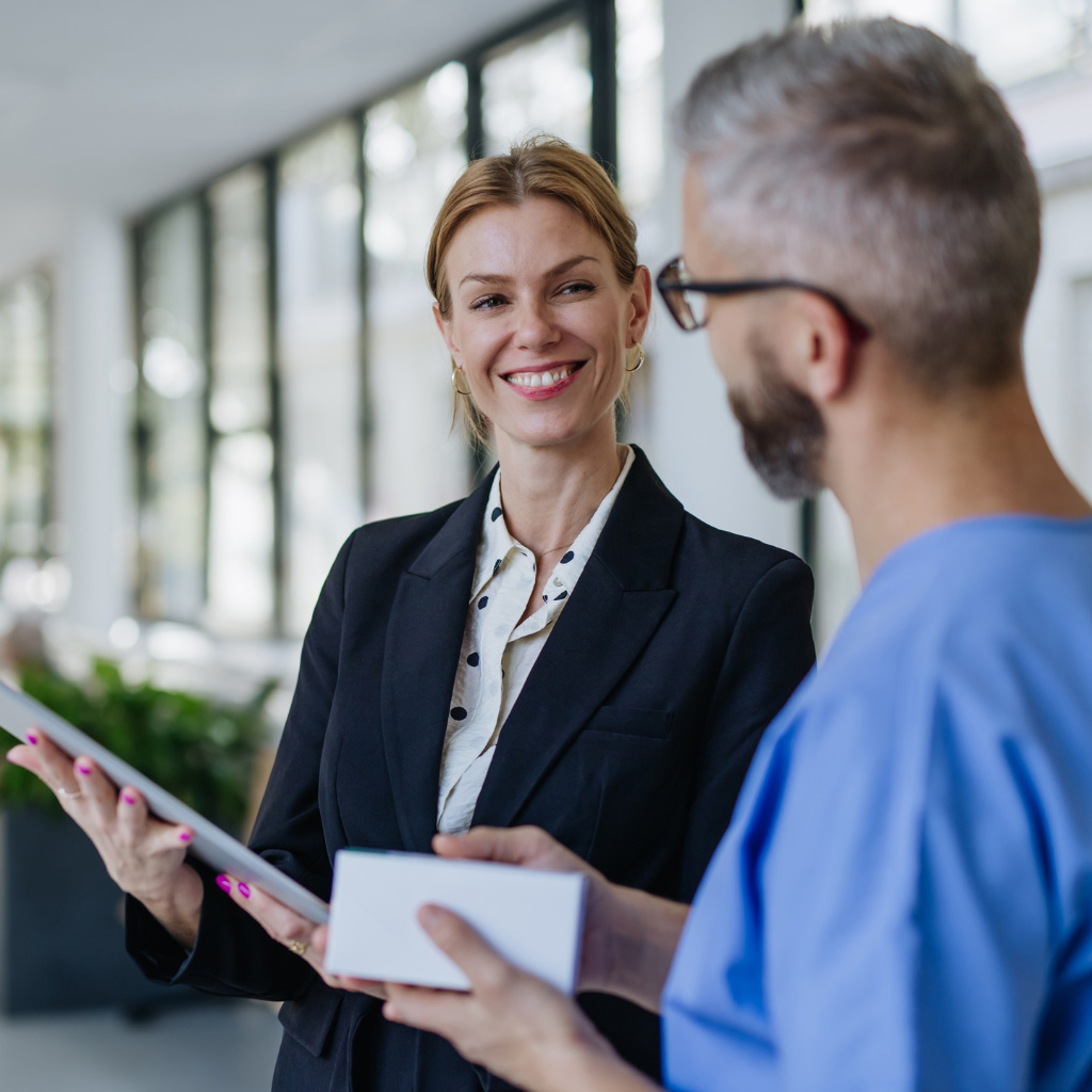 Addison Group's non clinical healthcare page, featuring a woman talking to a man in scrubs.