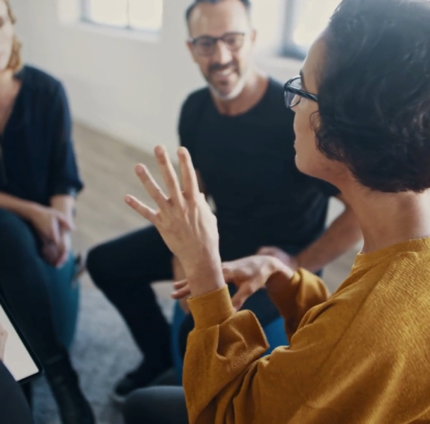 Addison group homepage, three coworkers chatting with one another